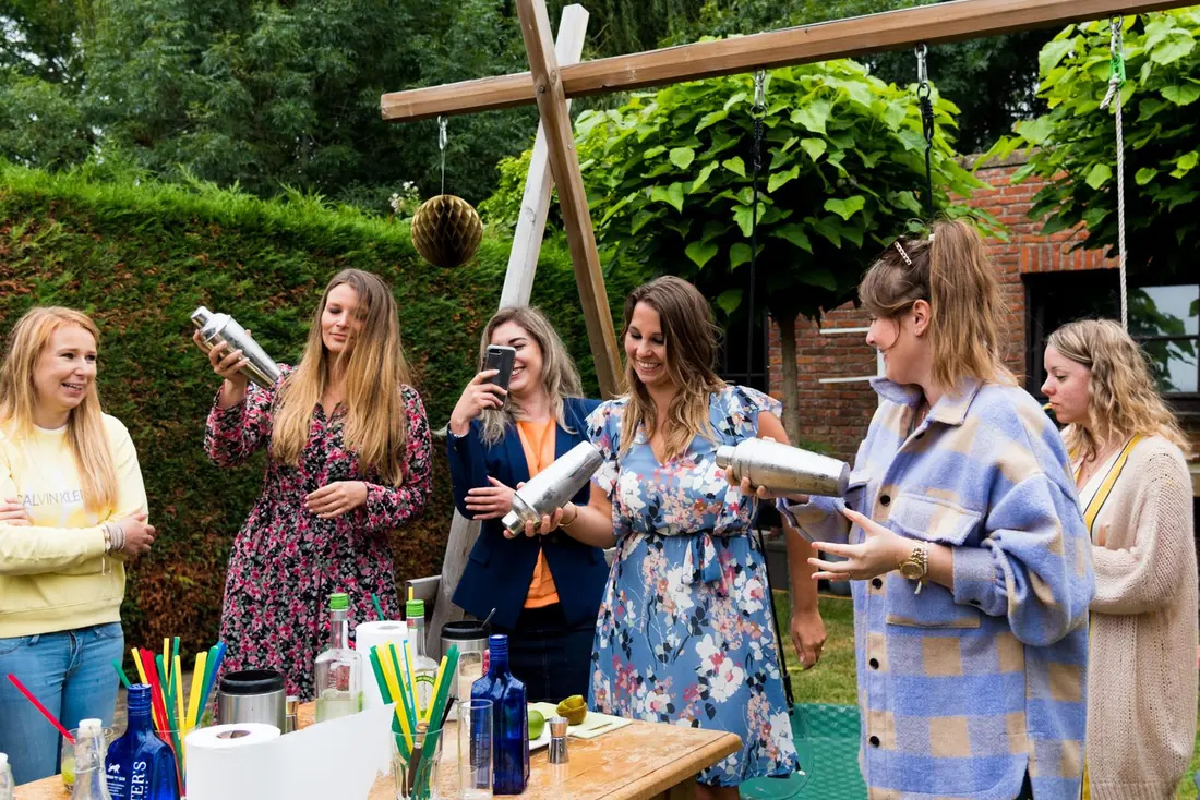 Collega’s shaken samen cocktails in de tuin