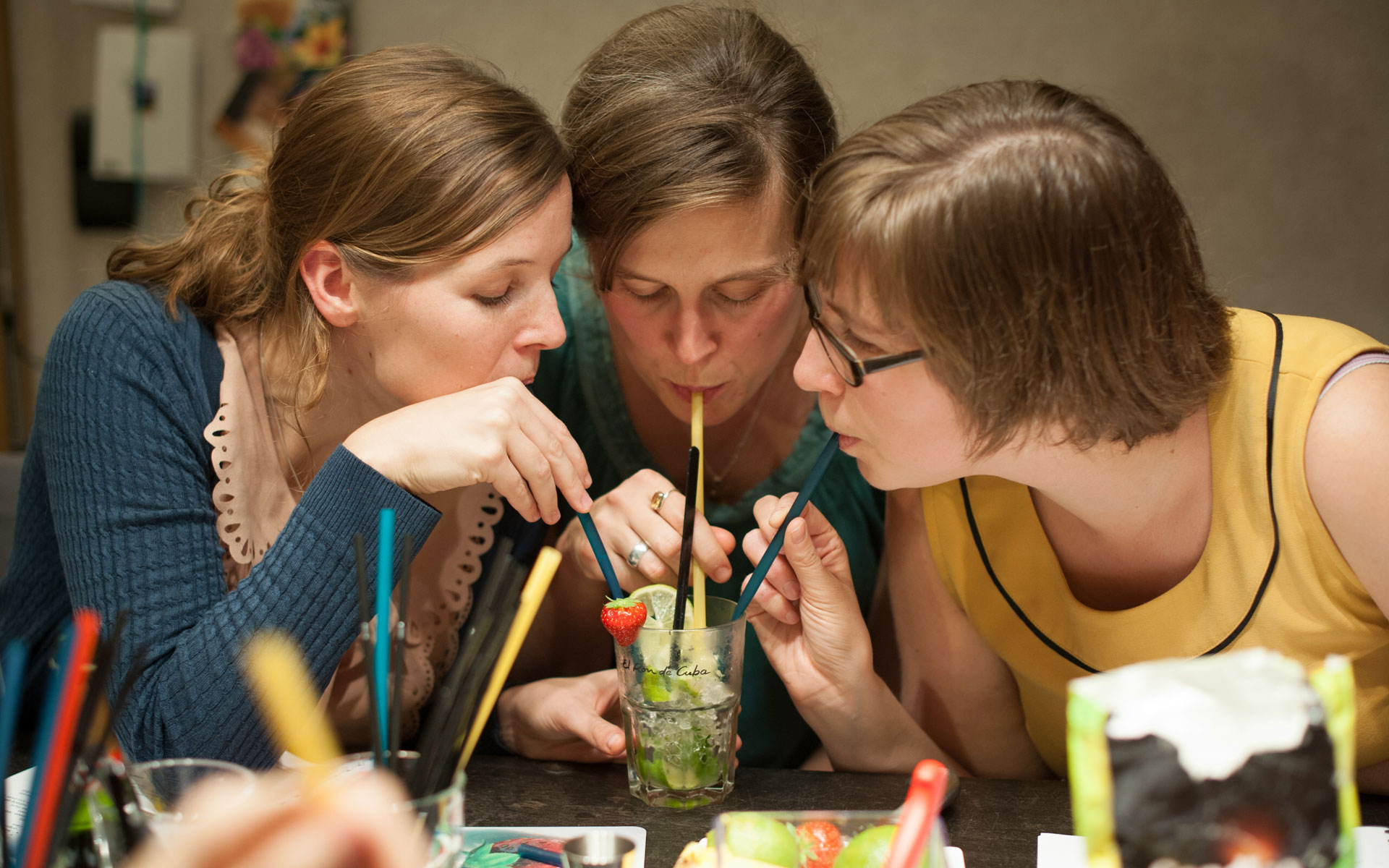 Drie vriendinnen proeven samen een cocktail