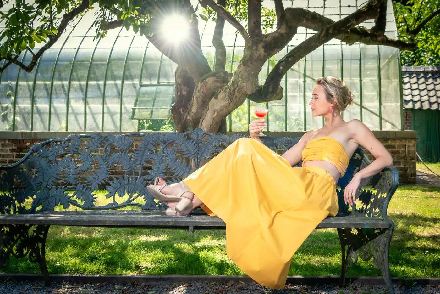 Vrouw in een gele jurk met een aardbeiendaiquiri
