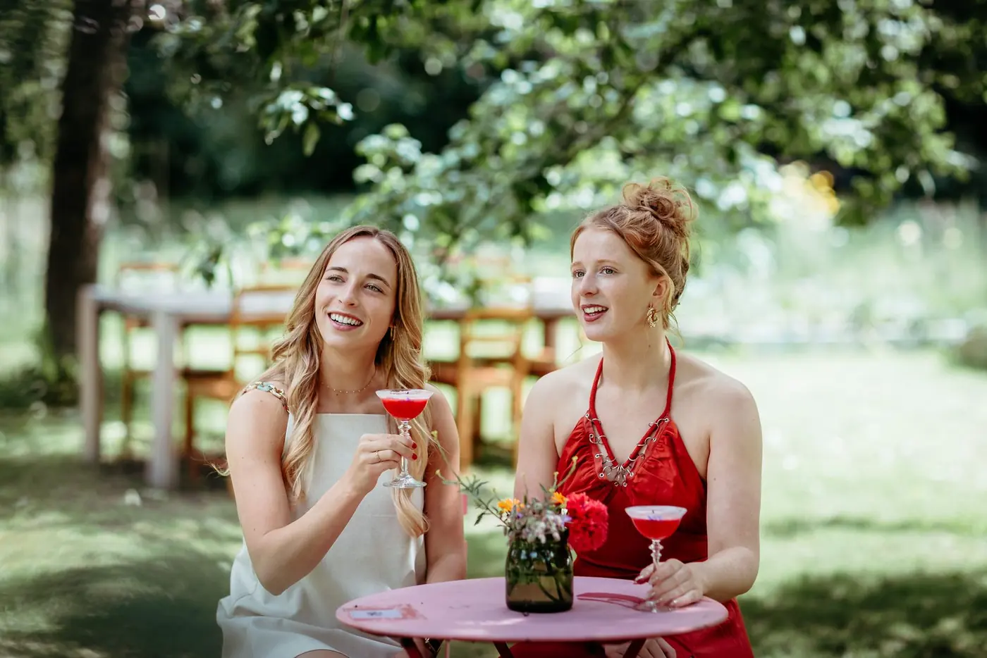 Twee vriendinnen klinken in de tuin