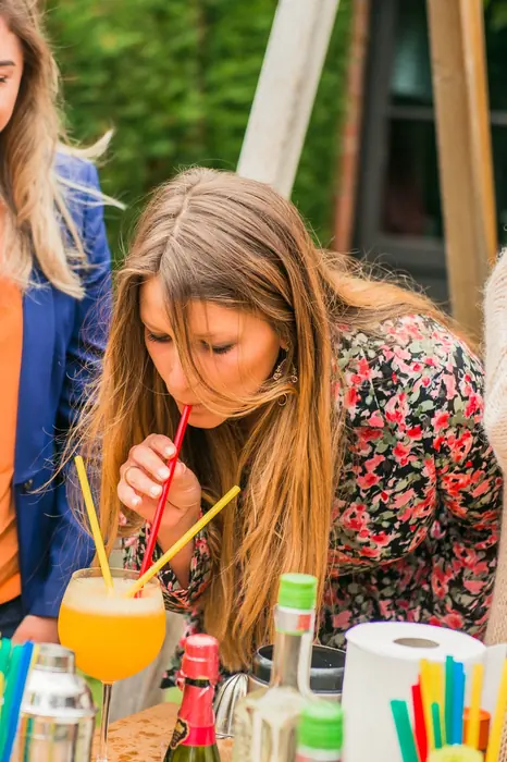 Deelneemster proeft haar cocktail met een rietje